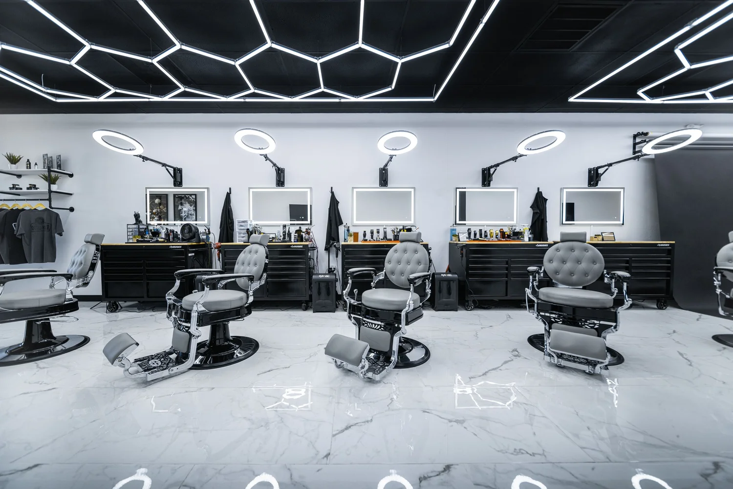 Inside Rick's Barbering — black tool chests, marble floor, hex ring lights
